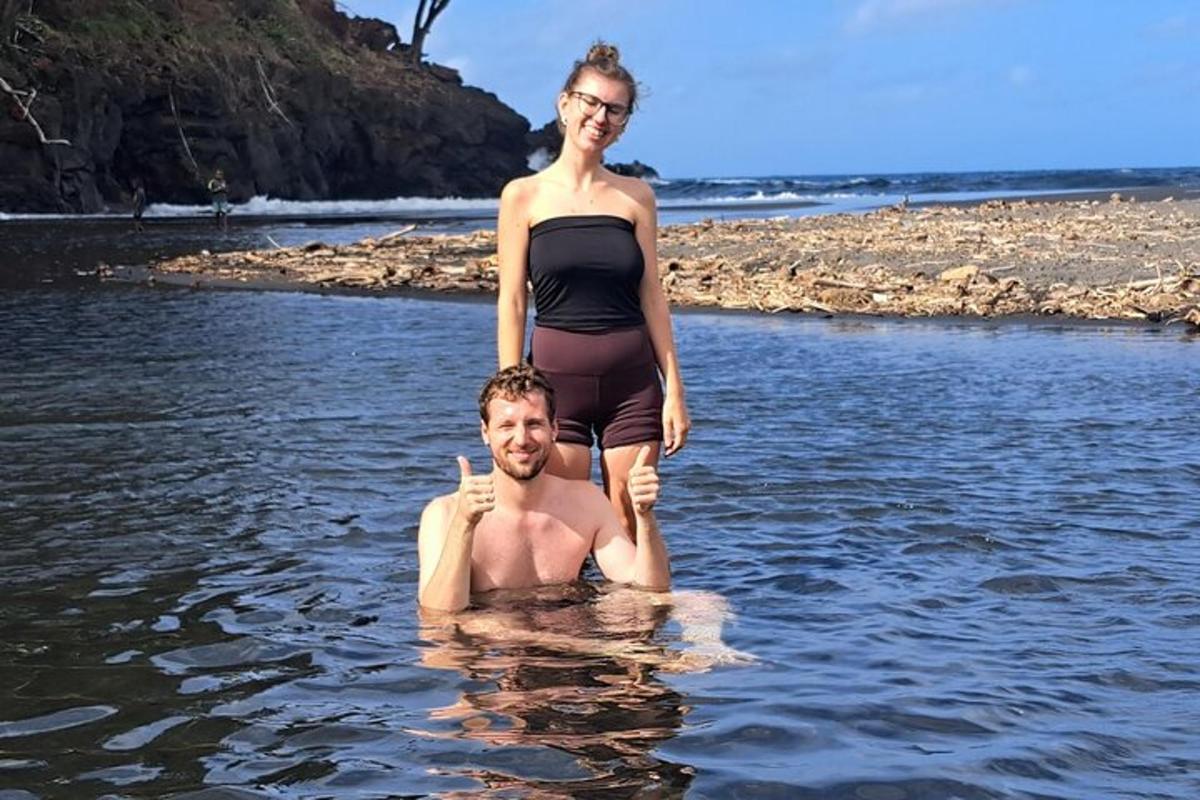 a woman standing on top of a man in the water