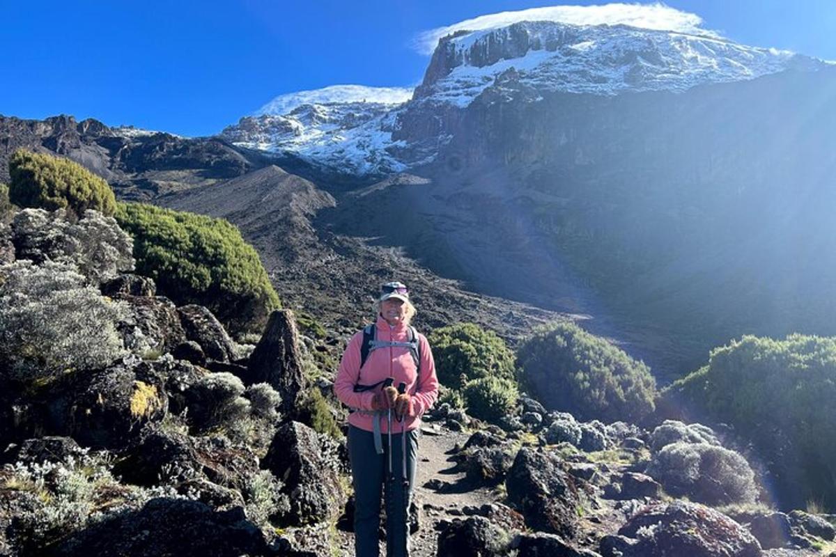 kona sem stendur á fjallstindi