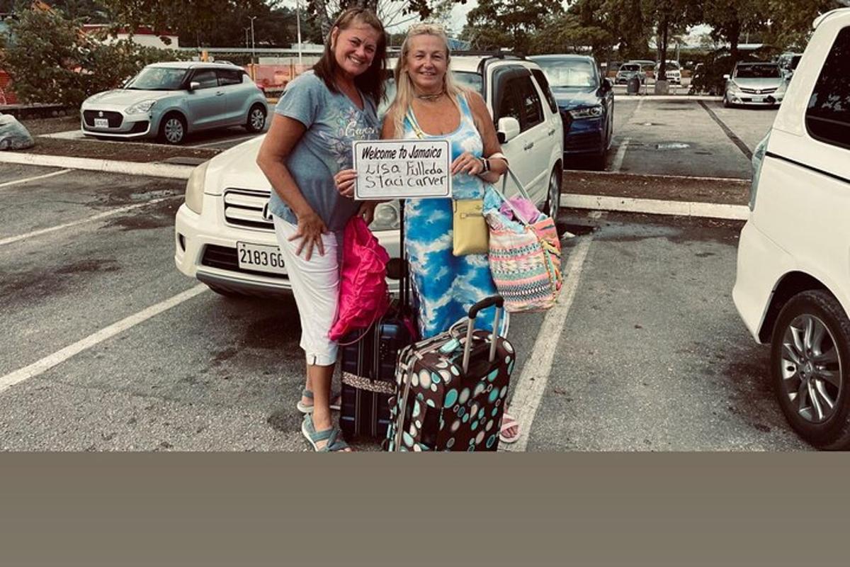 due donne in piedi in un parcheggio con un cartello in mano