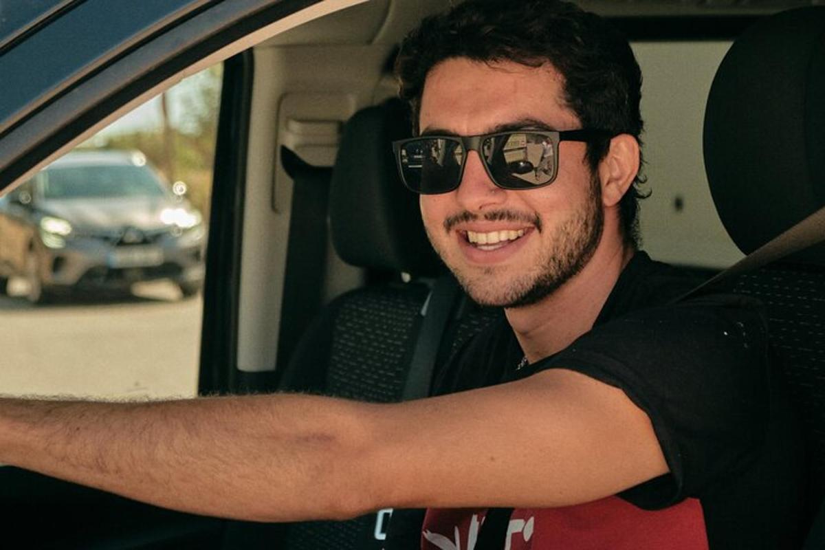 Un hombre con gafas de sol sentado en un coche.