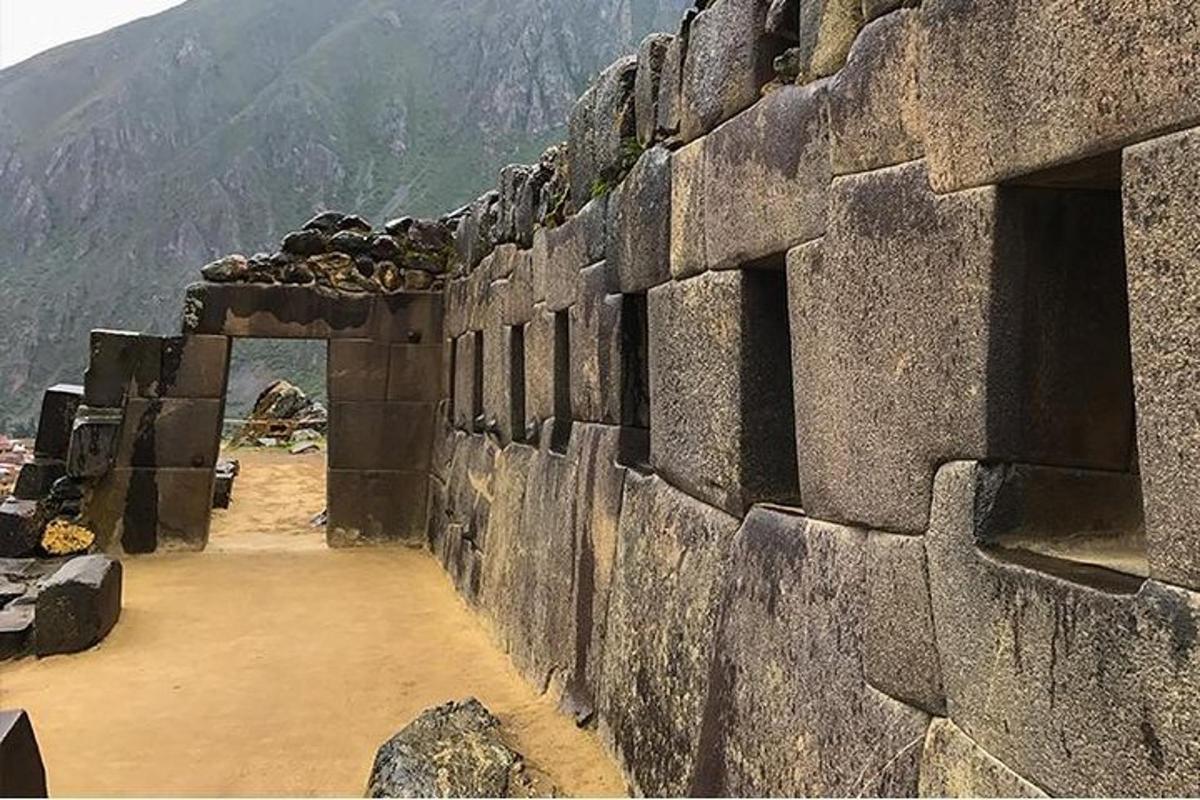 un gran mur de pedra amb una muntanya al fons