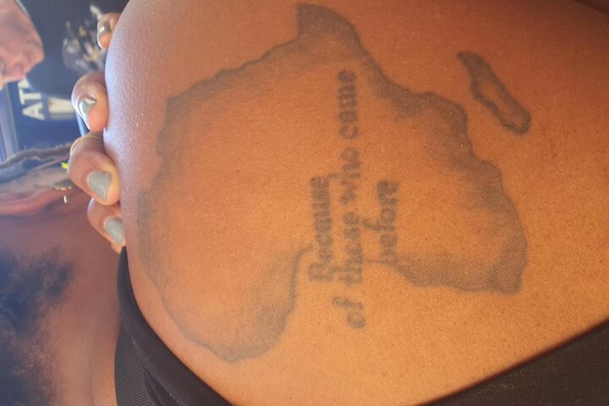 en mann med en tatovering på siden av halsen