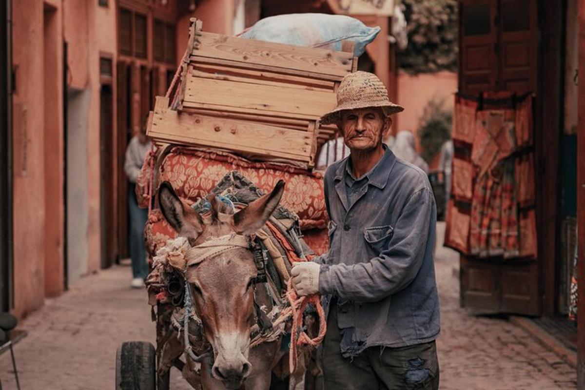 Un hombre de pie junto a un burro tirando de un carro.