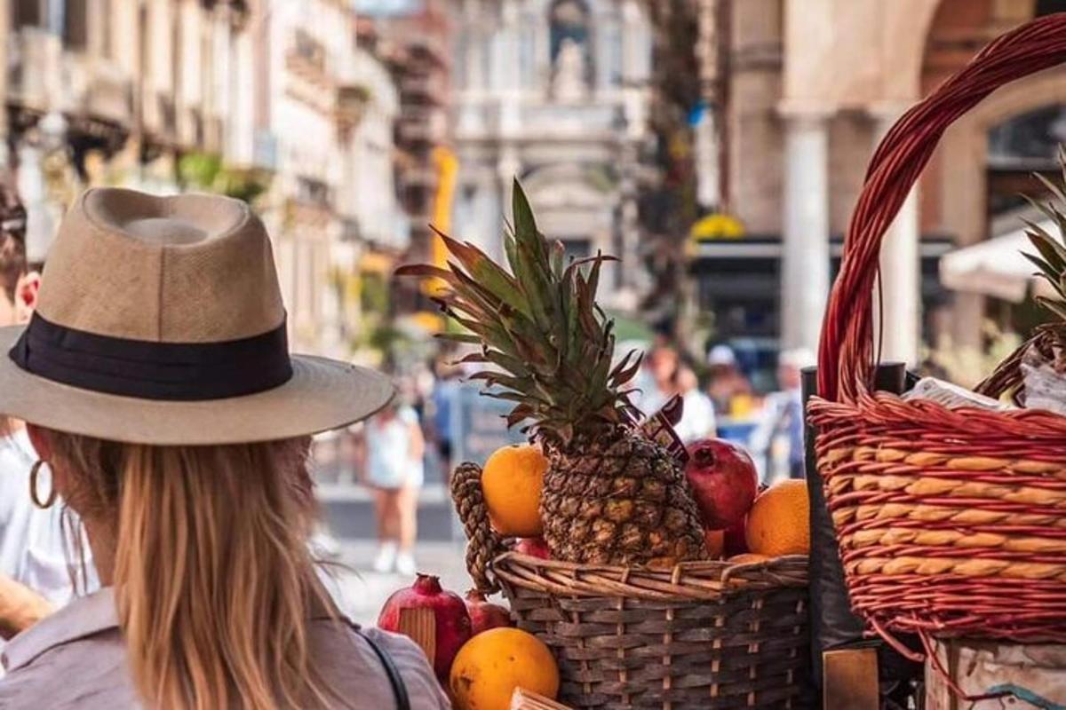 una donna che indossa un cappello con un cesto di frutta