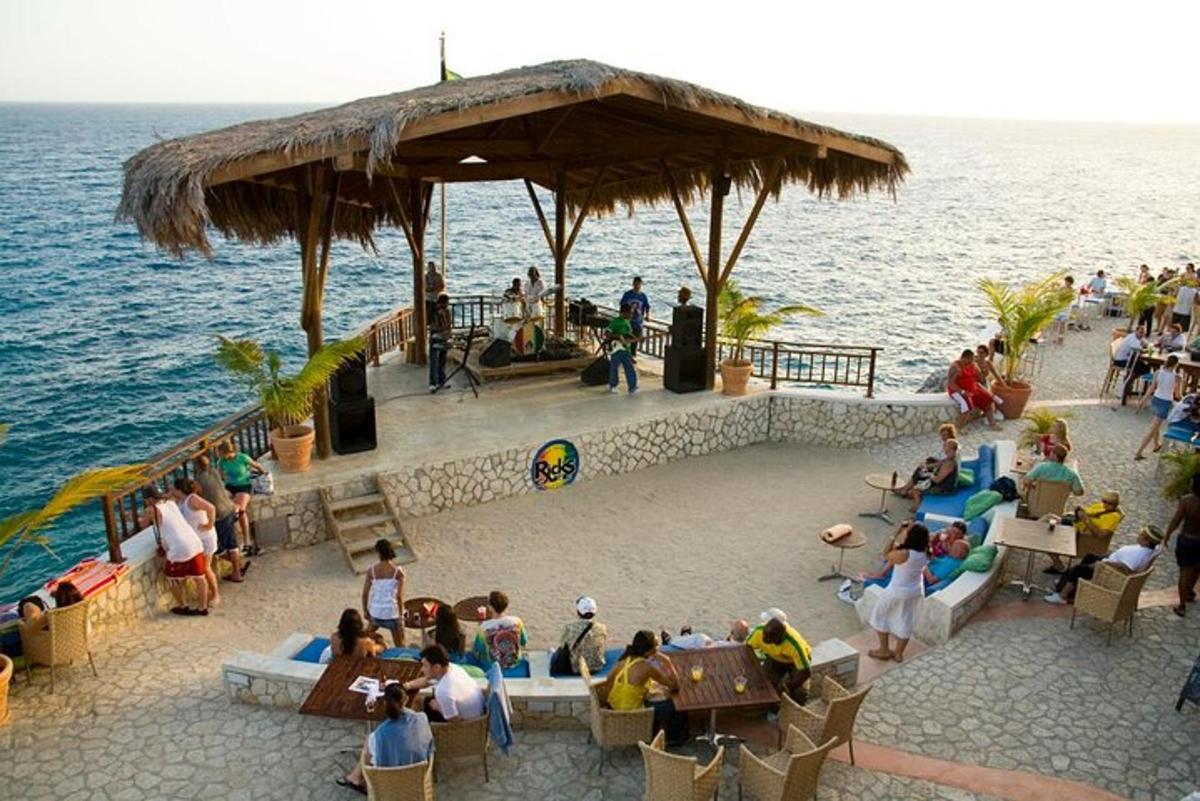 Un grupo de personas sentadas en un restaurante junto al agua.