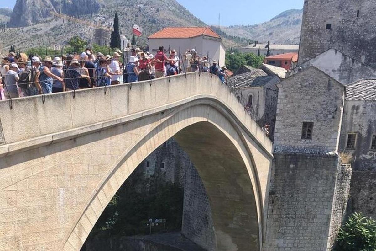 un gruppo di persone in piedi su un ponte