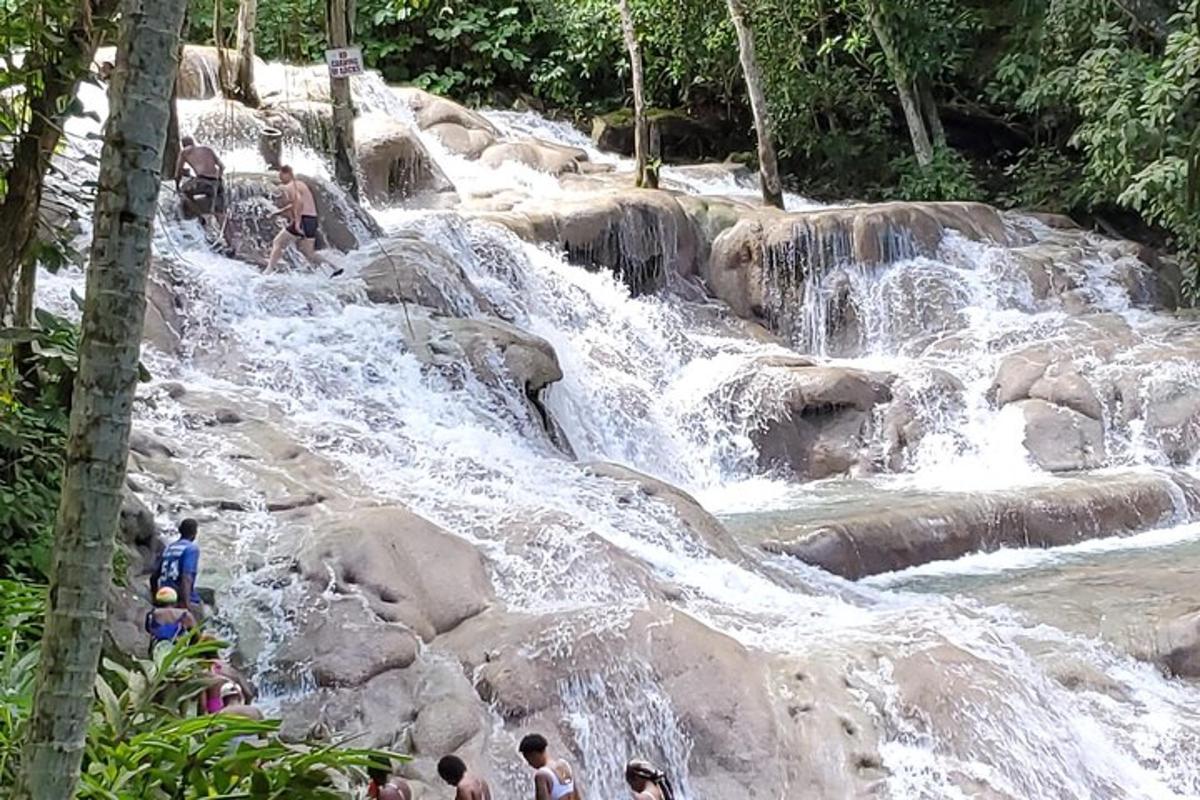 un grup de persones dempeus sobre les roques d'una cascada