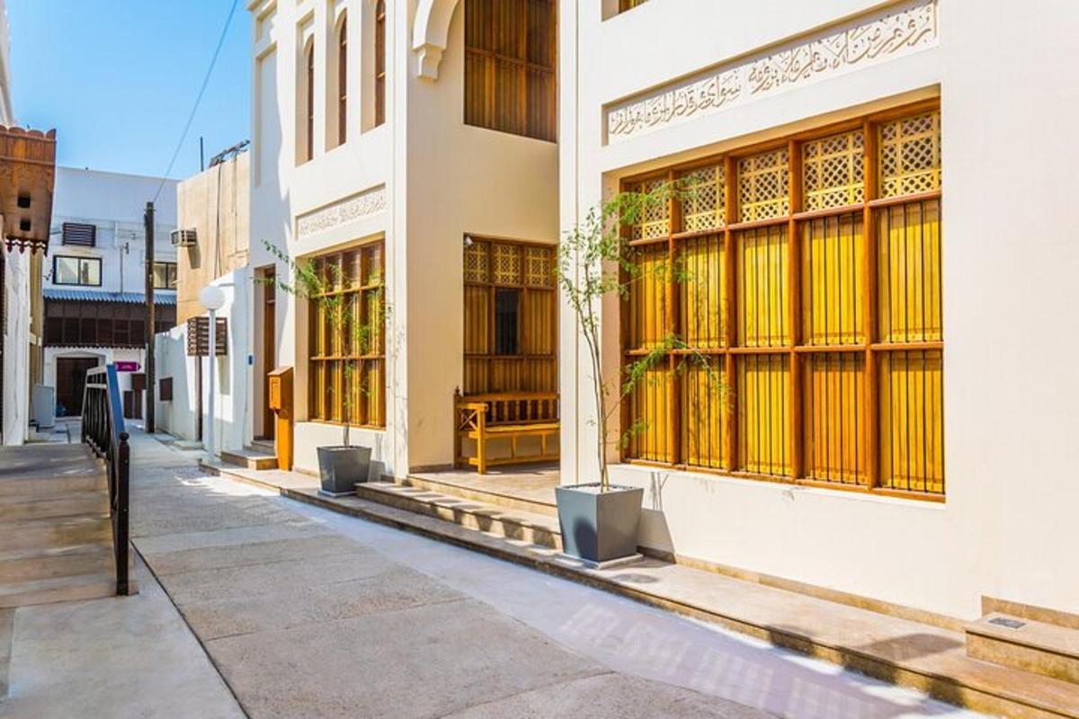 an empty street with a building with yellow windows
