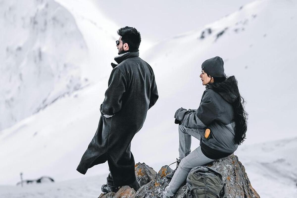 a man and a woman standing on top of a mountain