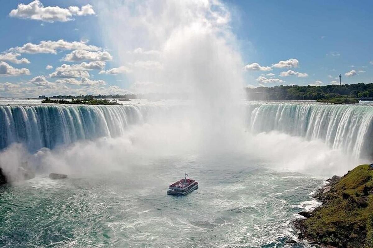 a boat in the water in front of a waterfall