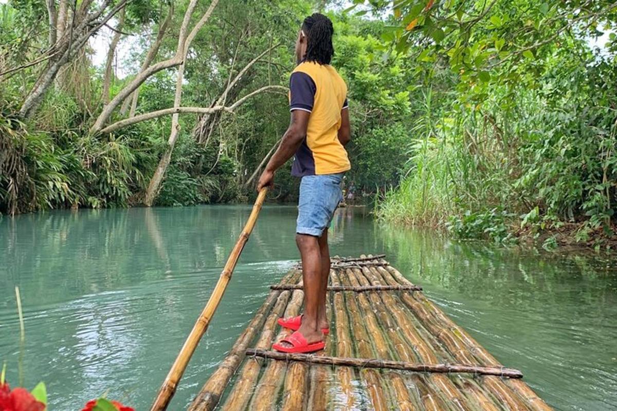 um homem está remando uma jangada de bambu na água