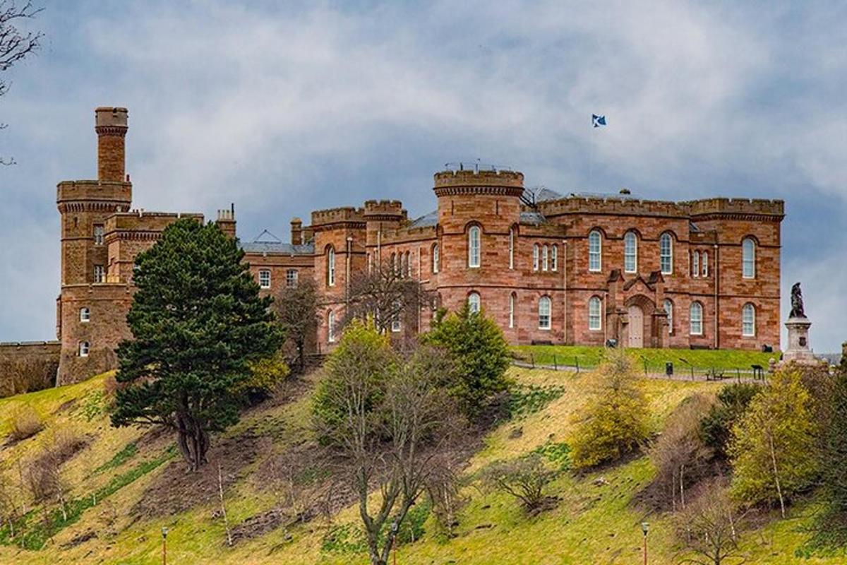 Un gran castillo en la cima de una colina cubierta de hierba