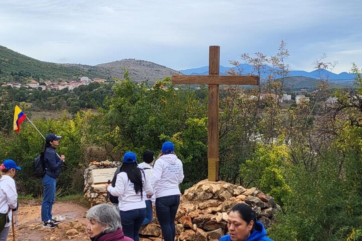 un grup de persones al voltant d'una creu de fusta