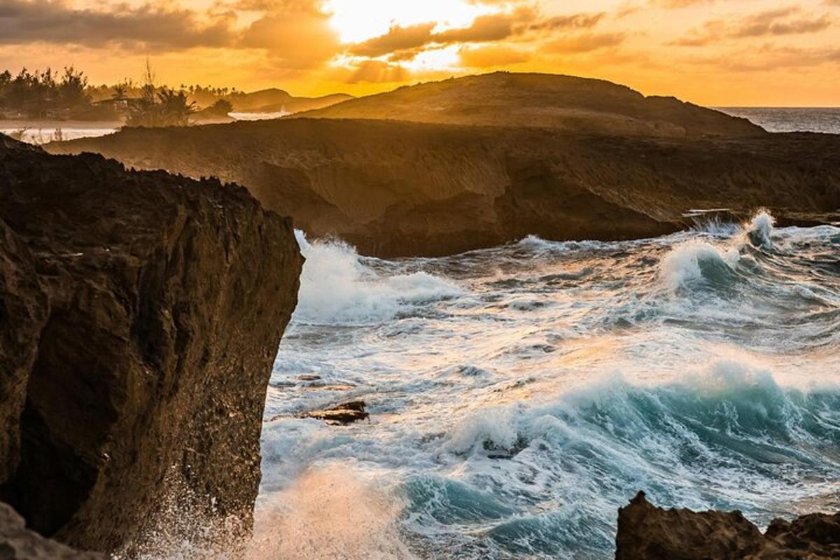 una posta de sol sobre l'oceà amb onades i roques