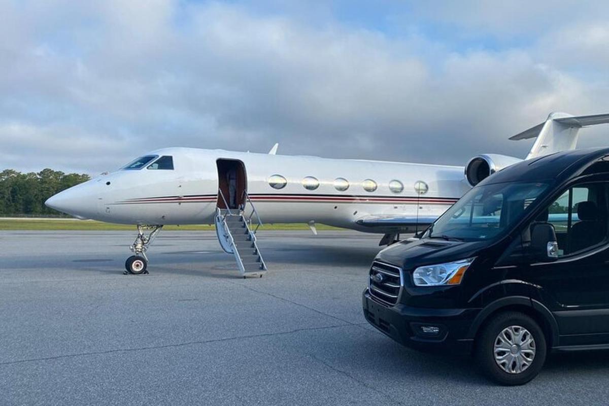 a car parked next to a plane on a runway