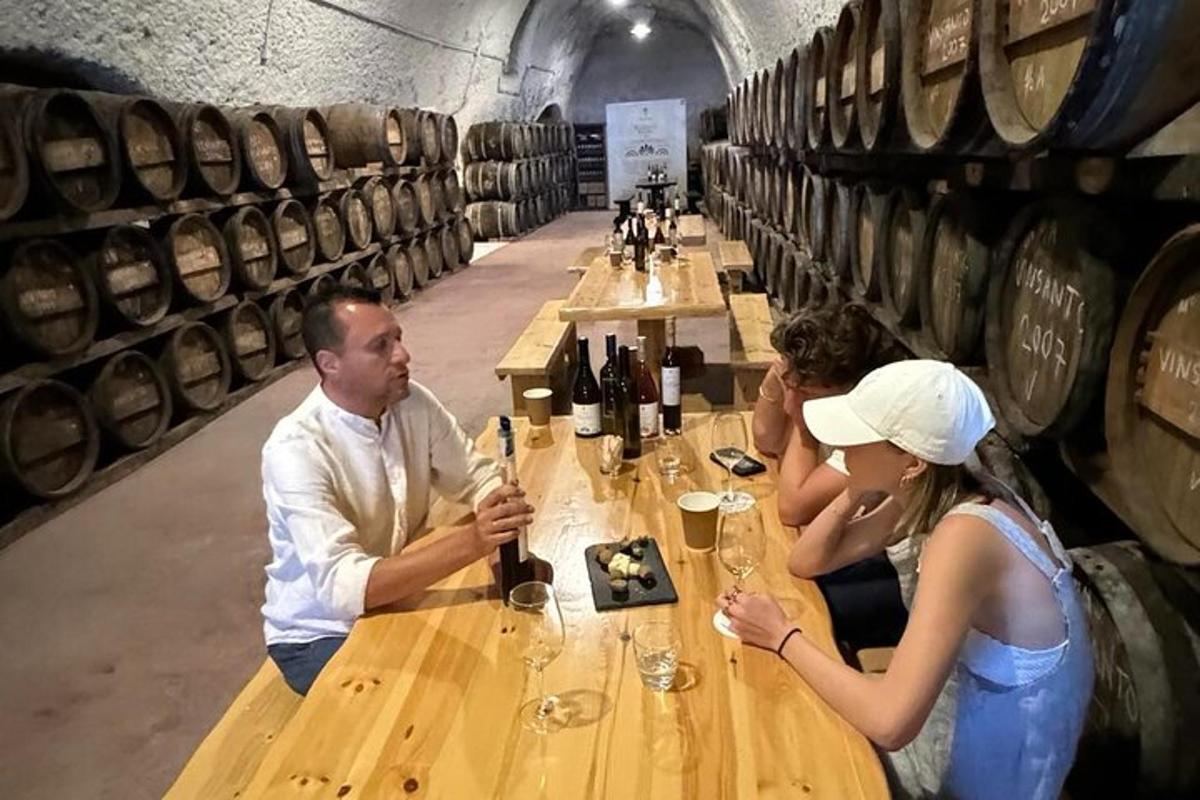 un gruppo di persone sedute a un tavolo in una cantina vinicola