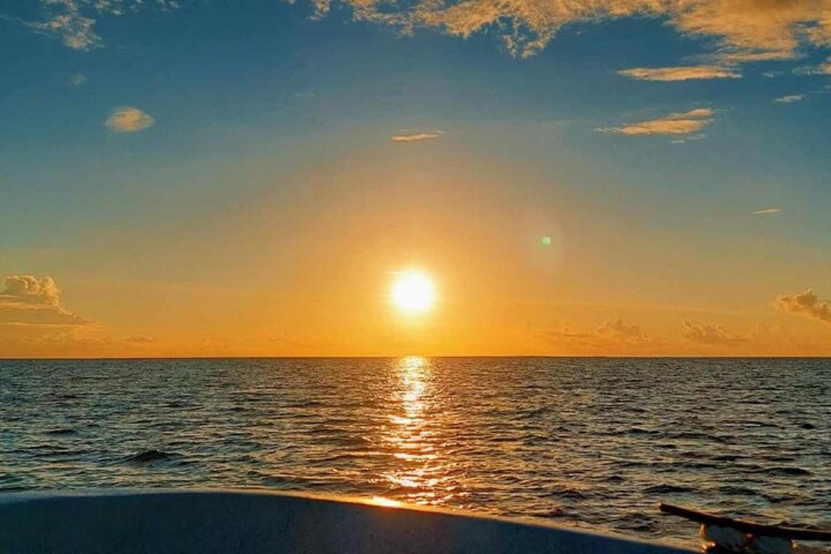 a view of the sunset from a boat in the ocean