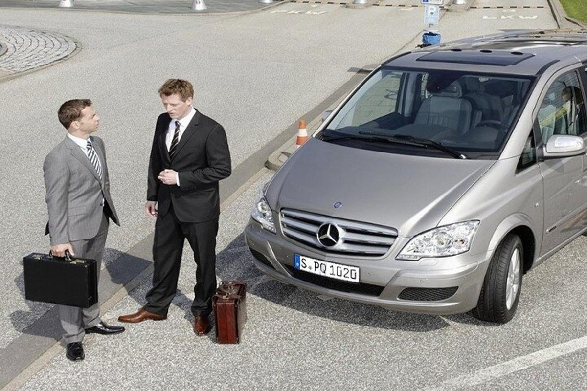 Kaks ülikondades meest seisavad auto kõrval