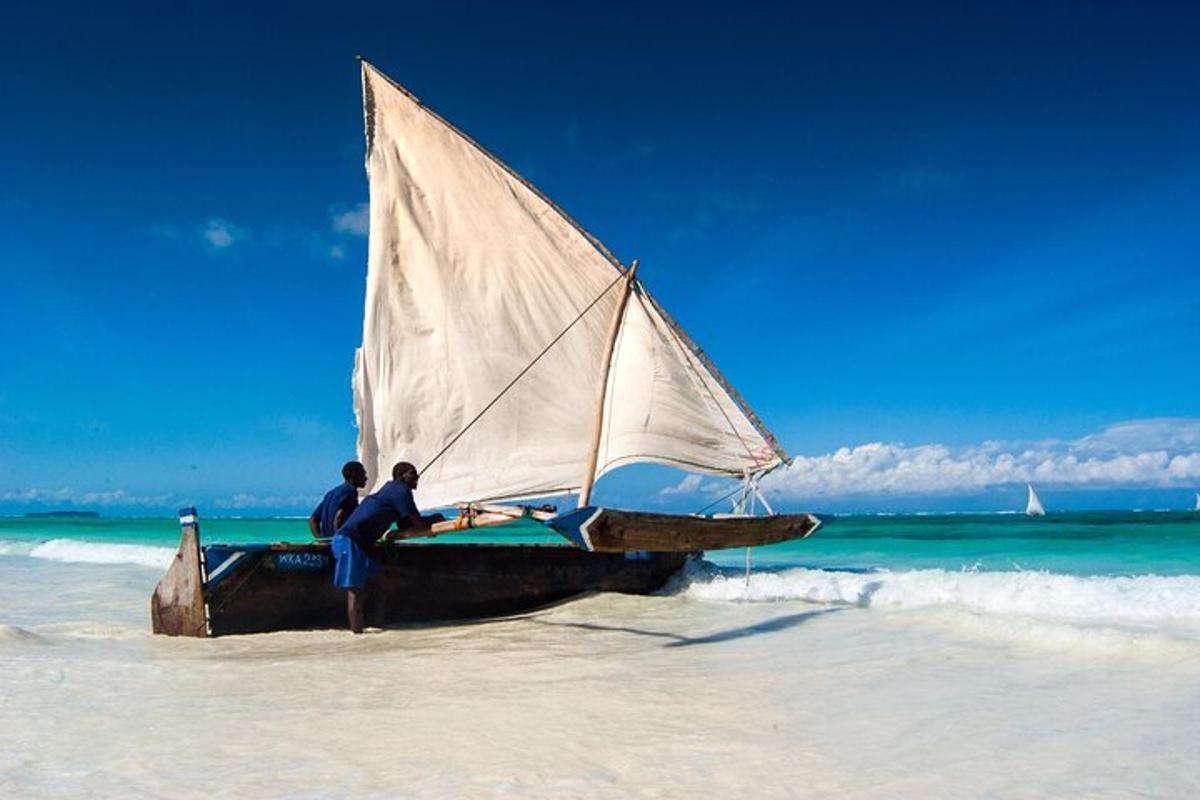 Dos personas de pie en un velero en una playa