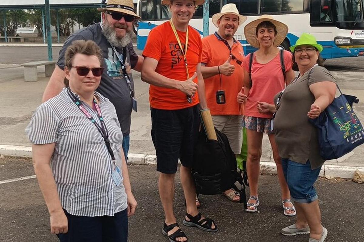 grupė žmonių, stovinčių priešais autobusą