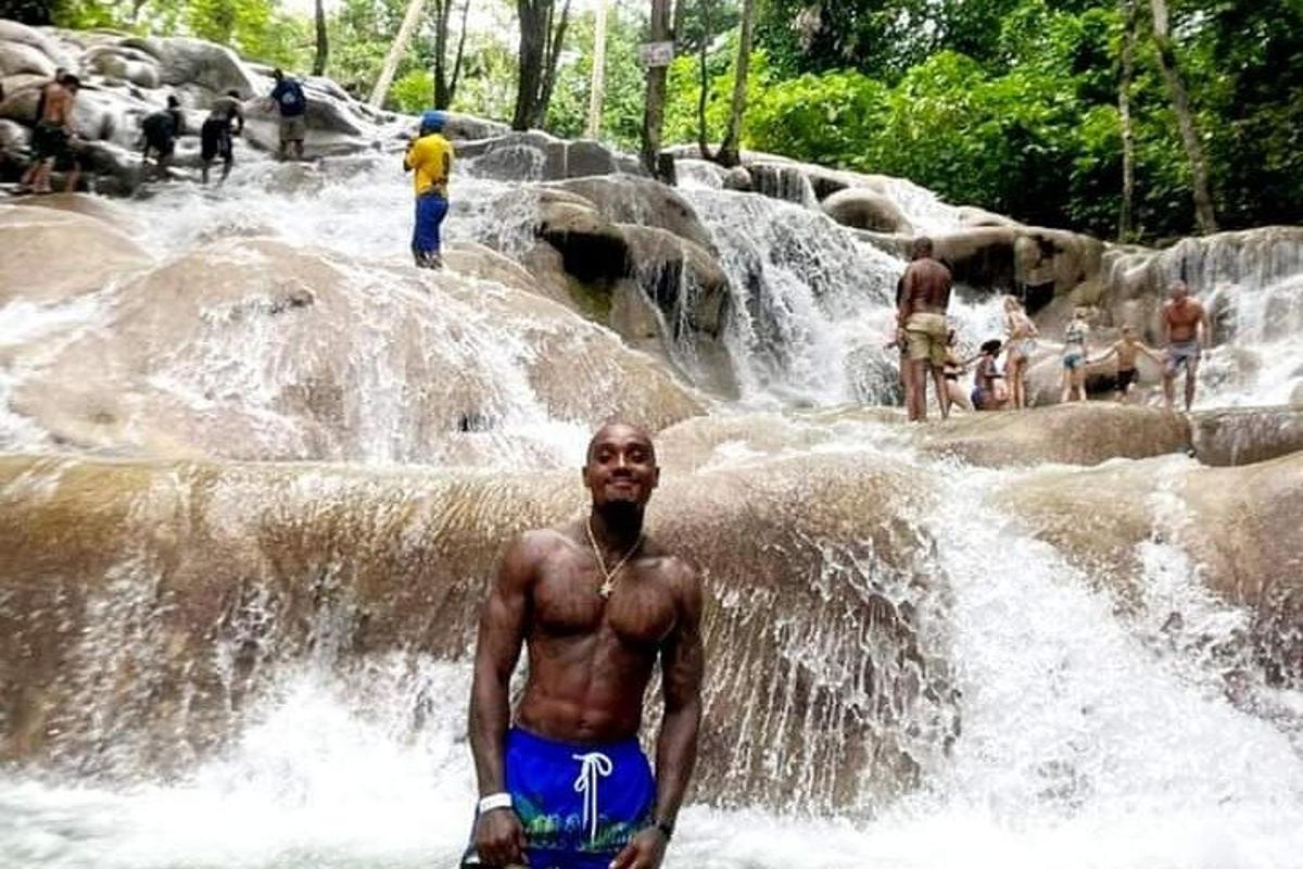 un hombre parado frente a una cascada