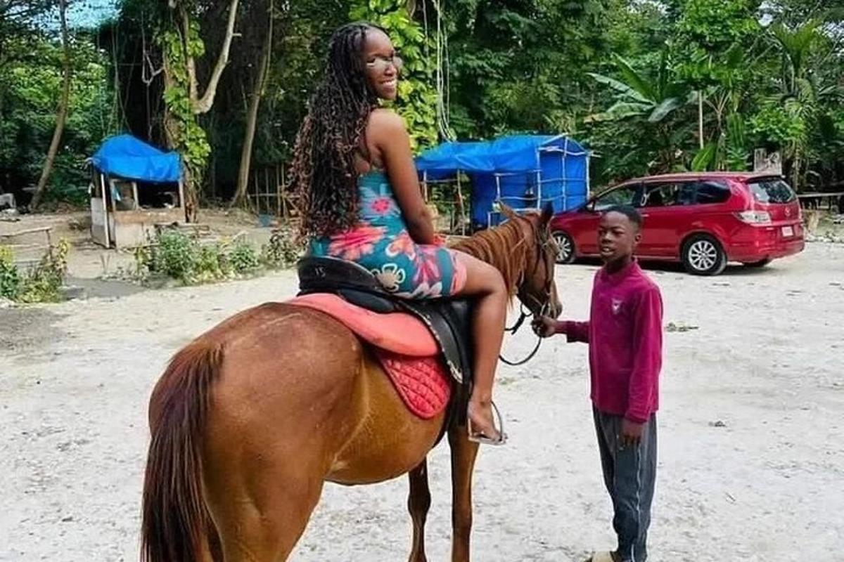 Una joven sentada en un caballo junto a un hombre