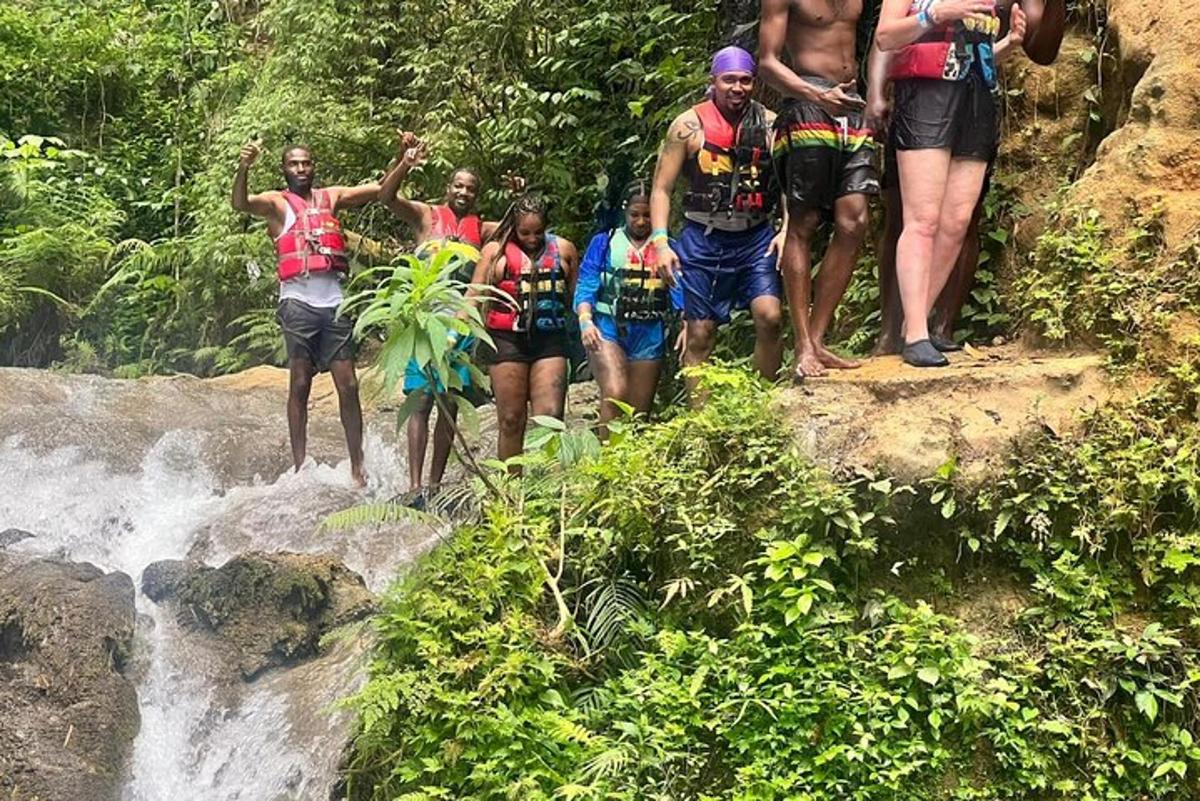 un gruppo di persone in piedi in cima a una cascata