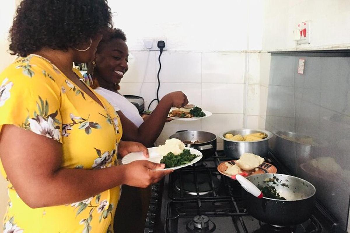 dua wanita berdiri di dapur sambil memegang piring berisi makanan