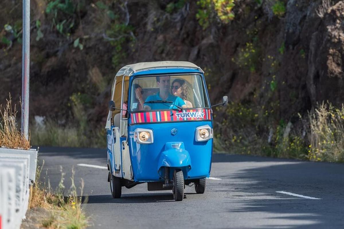 un piccolo veicolo blu che percorre una strada