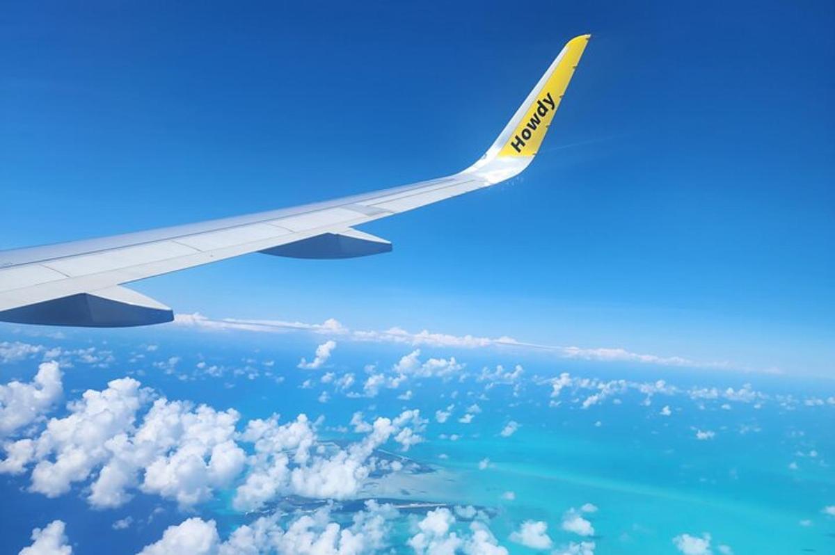 una vista de l'ala d'un avió volant sobre l'oceà