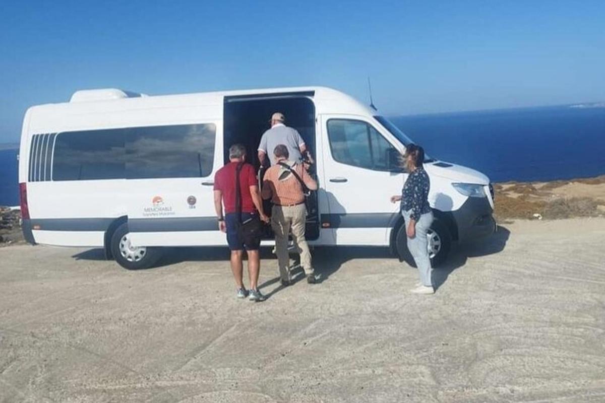 un gruppo di persone in piedi fuori da un furgone bianco