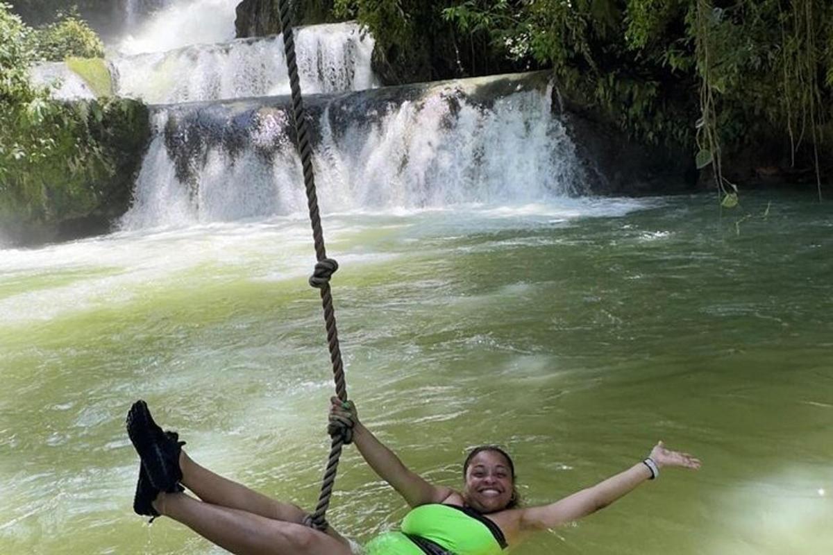 een man in het water voor een waterval