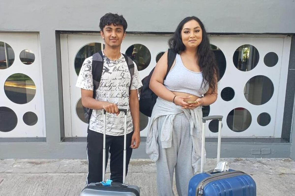 egy férfi és egy nő állnak a csomagjaikkal