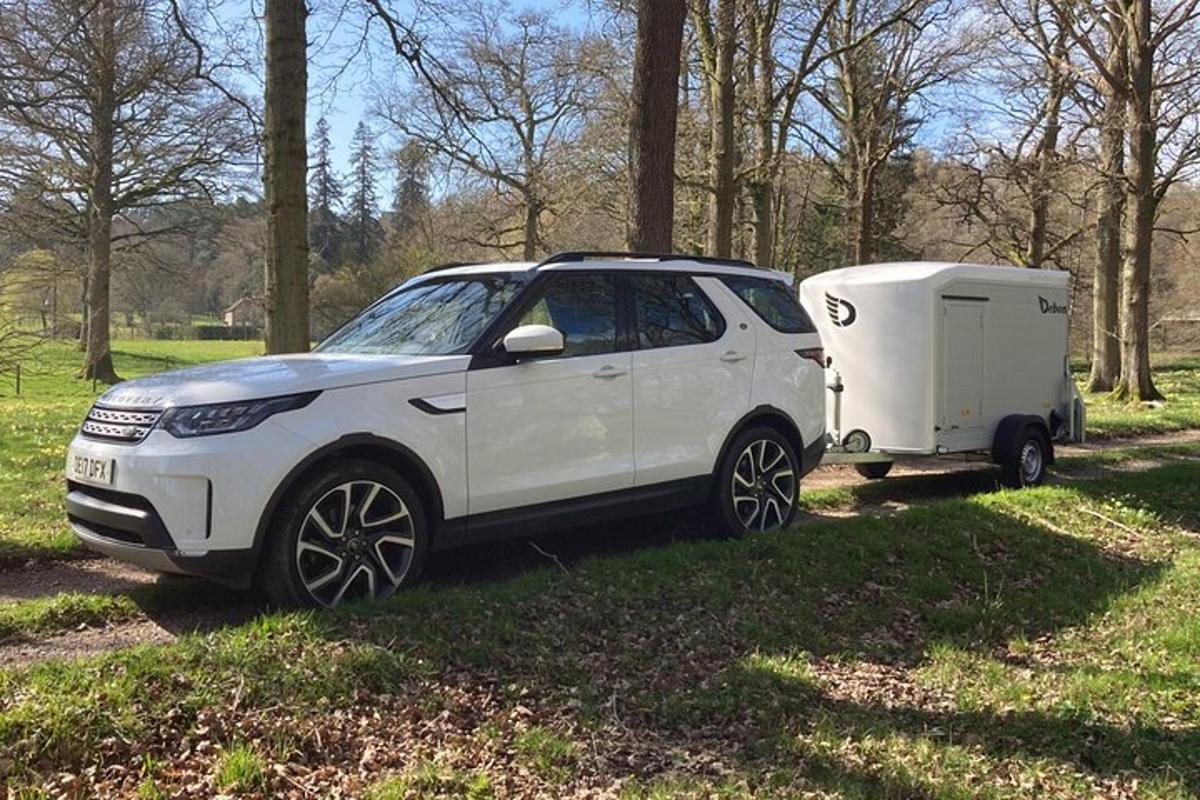 a white car with a trailer and a camper