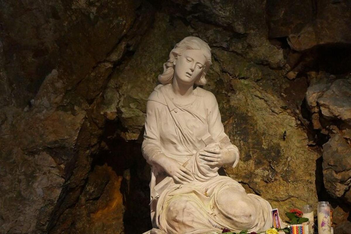 socha ženy sediacej na skale