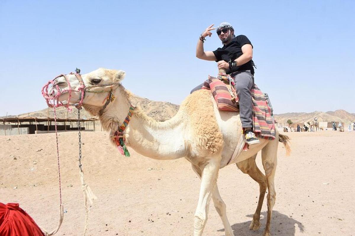 un home muntat en un camell al desert