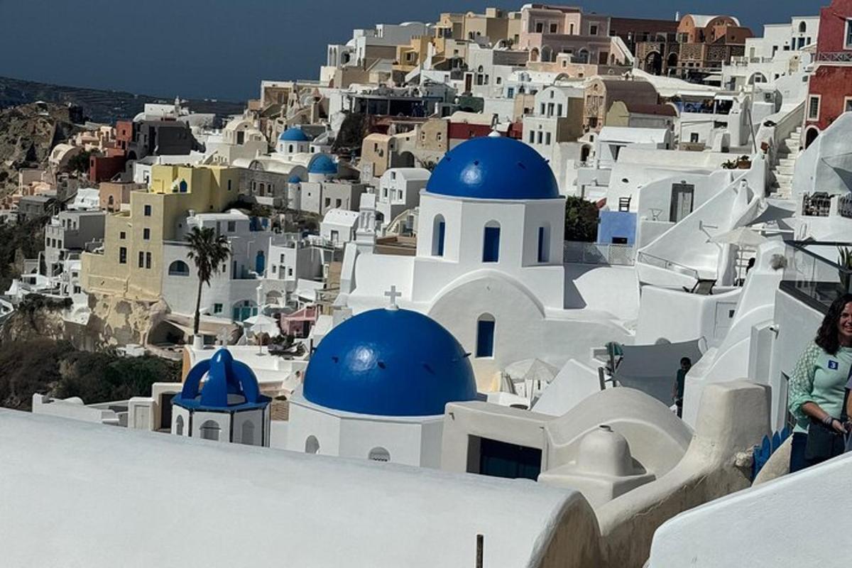 Μια γυναίκα στέκεται στην οροφή ενός κτιρίου με θέα ένα χωριό