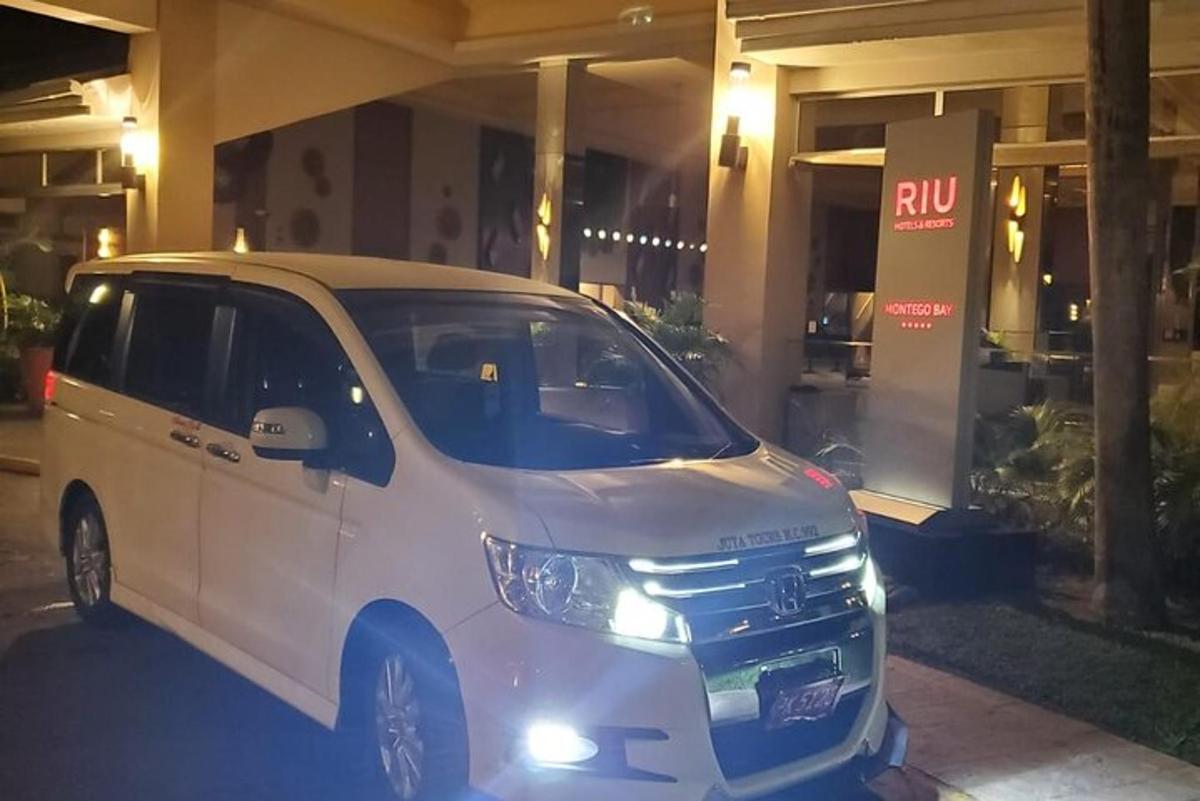 uma van branca estacionada em frente a um prédio