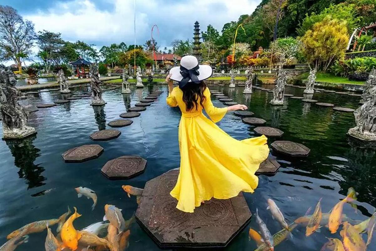 una donna in un vestito giallo in uno stagno con i pesci