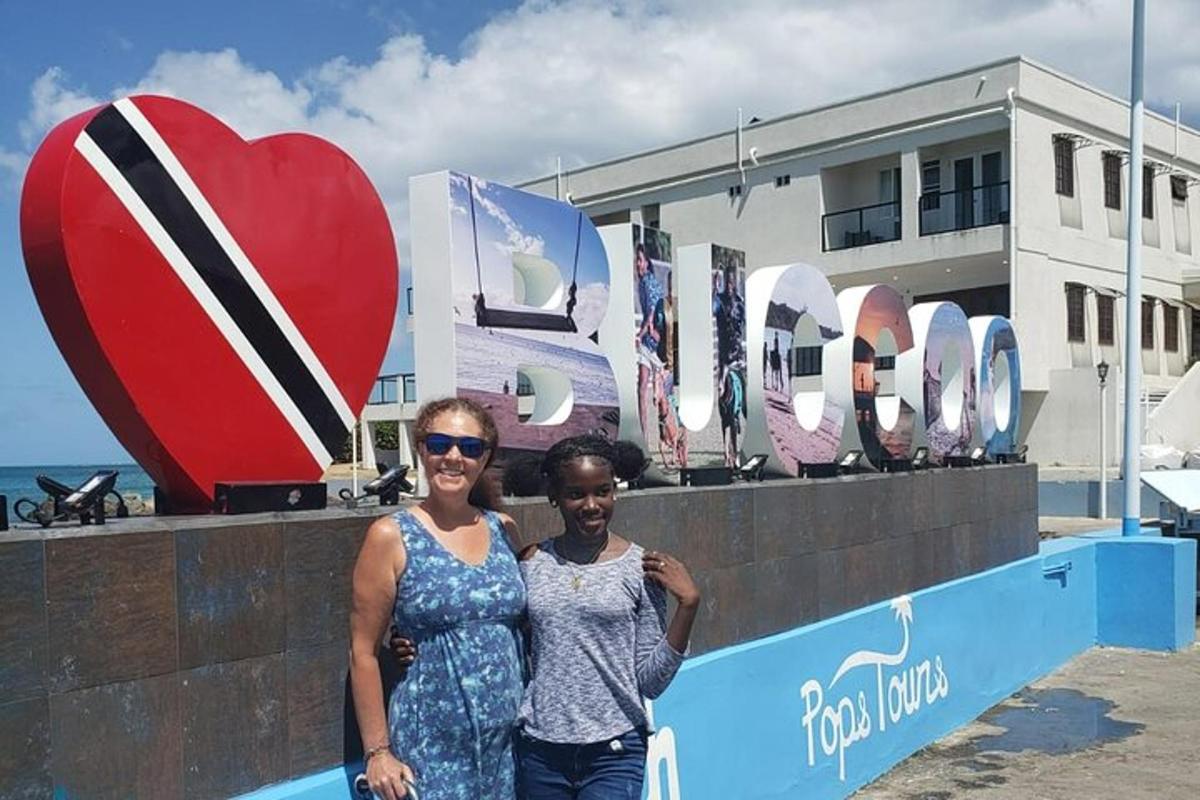 two women standing in front of a wall with a heart