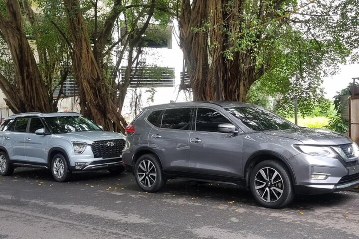 dua buah kereta diletakkan bersebelahan di sebatang jalan