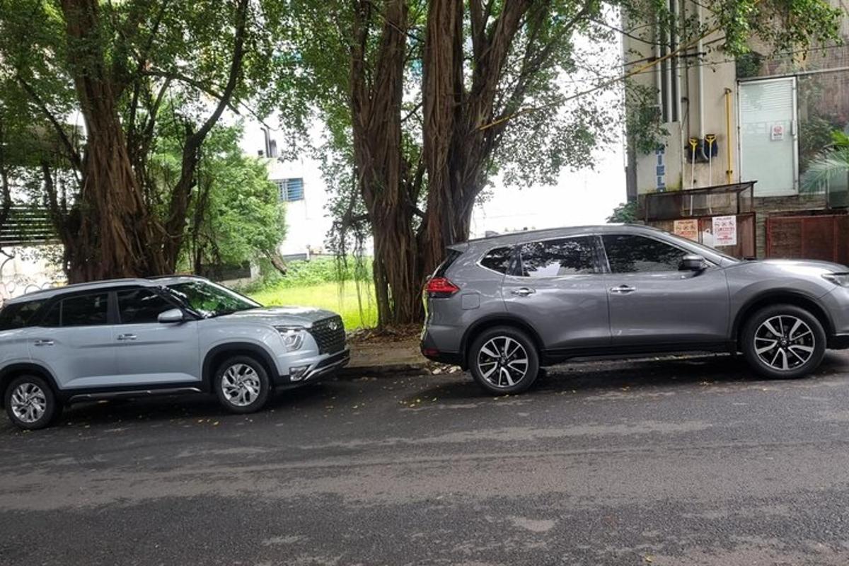 dua buah kereta diletakkan bersebelahan di sebatang jalan