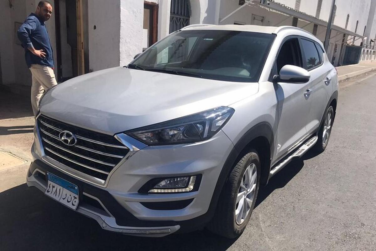 un uomo è in piedi accanto a un'auto bianca