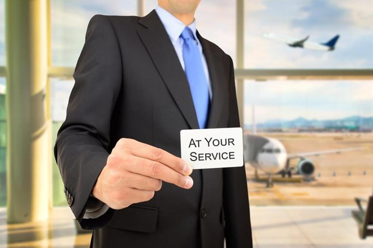 a man in a suit holding a sign that reads at your service