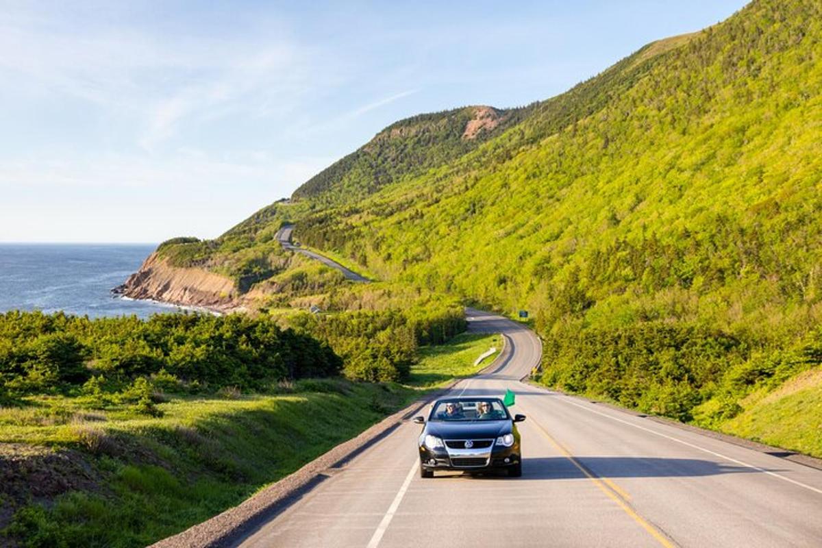 a car driving down a road near the ocean