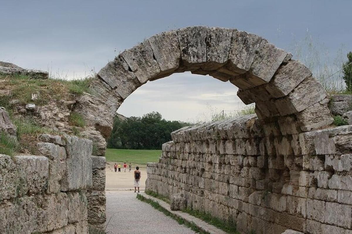 o arcadă într-un zid de piatră prin care trece o persoană