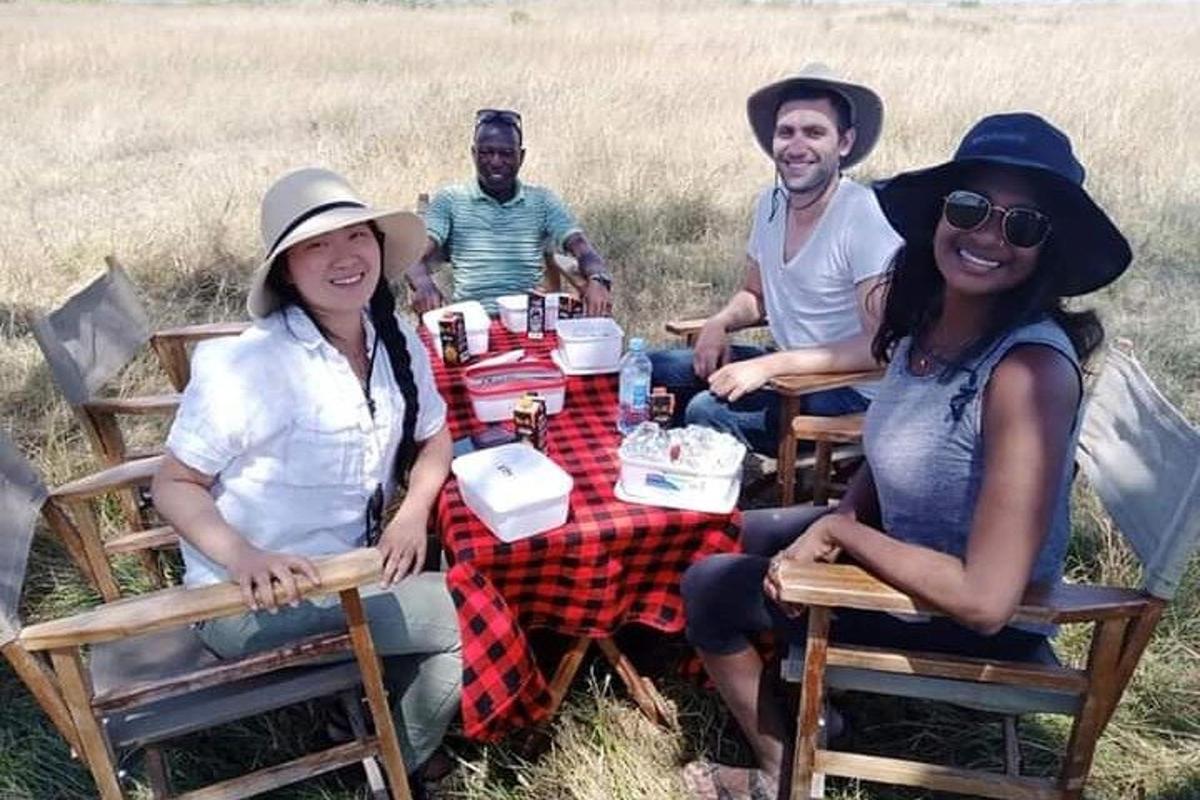 un grup de oameni așezați la o masă de picnic