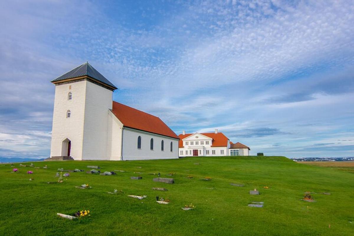 un grande edificio bianco su una collina erbosa con una chiesa
