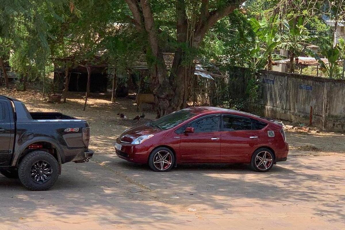 sebuah kereta merah diletakkan di sebelah sebuah lori hitam