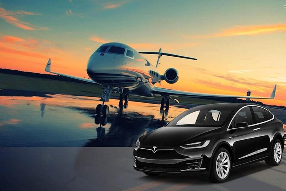 a black car parked next to a plane